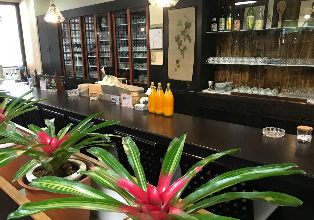 un bar avec deux plantes en pot dans un restaurant dans l'établissement Daikanso, à Chikushino 5 autres photos