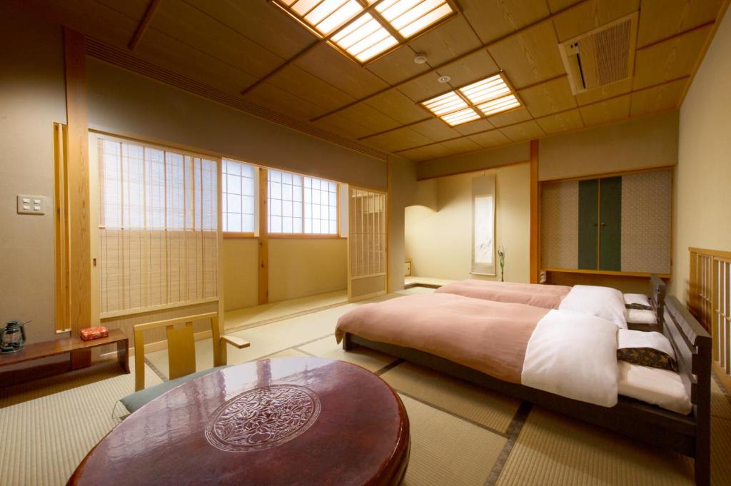 une chambre avec un grand lit et une table dans l'établissement Oyado Tamaki, à Shibukawa 37 autres photos
