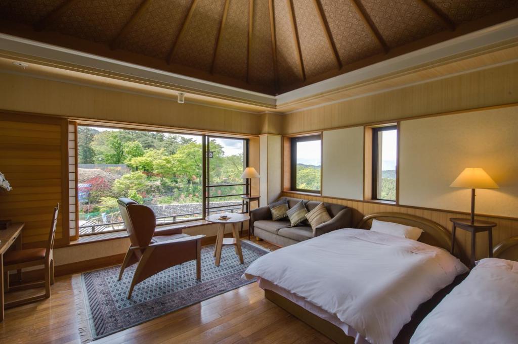 - une chambre avec un lit, un canapé et des fenêtres dans l'établissement Oyado Tamaki, à Shibukawa