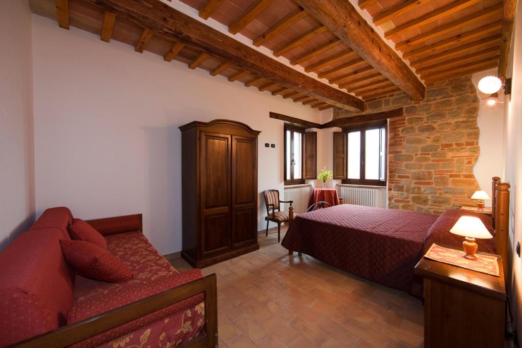 une chambre avec un lit et un canapé dans une pièce dans l'établissement Collerovere Country House, à SantʼAngelo in Pontano