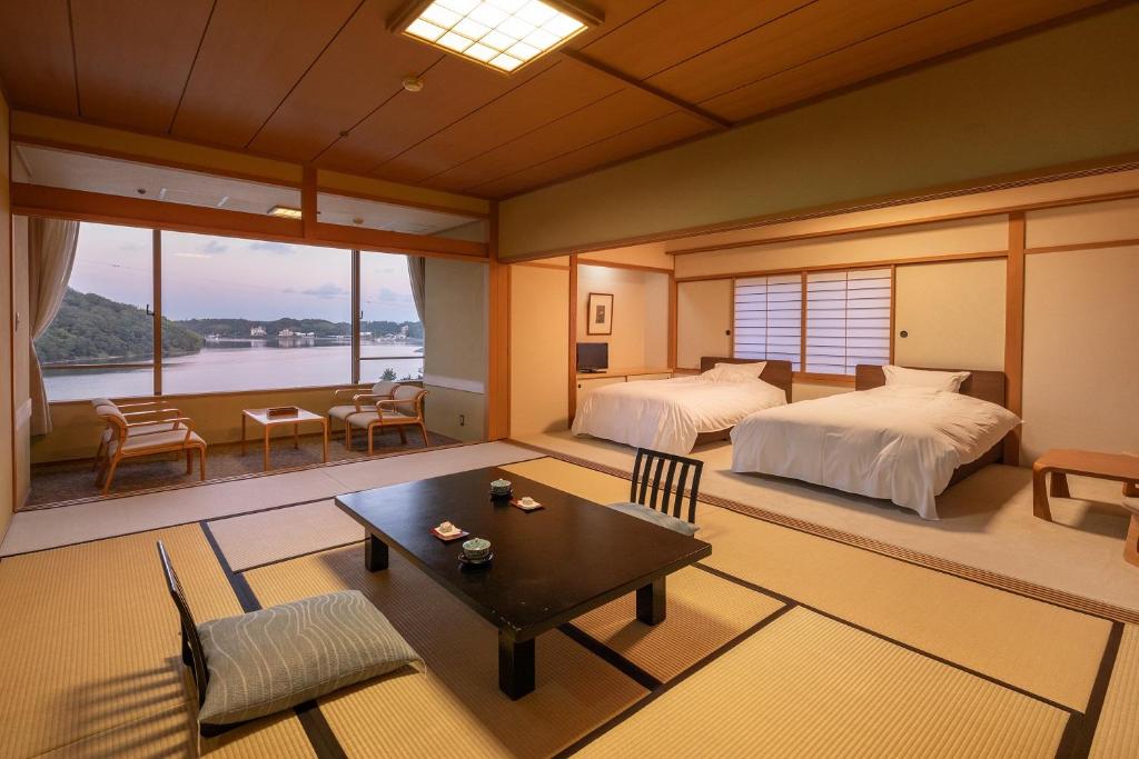 une chambre avec deux lits et une table et des chaises dans l'établissement Sansuikan Kinryu, à Hamamatsu