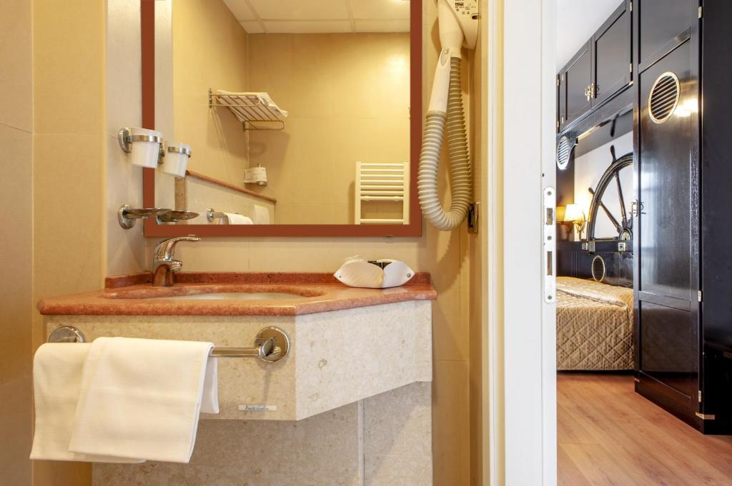 une salle de bain avec un lavabo et un miroir dans l'établissement Hotel Villa Lo Scoglietto, à San Vincenzo