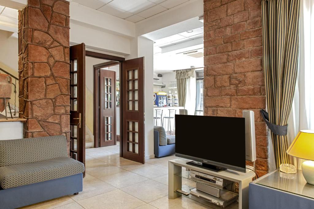 un salon avec une télévision sur une table dans l'établissement Hotel Villa Lo Scoglietto, à San Vincenzo