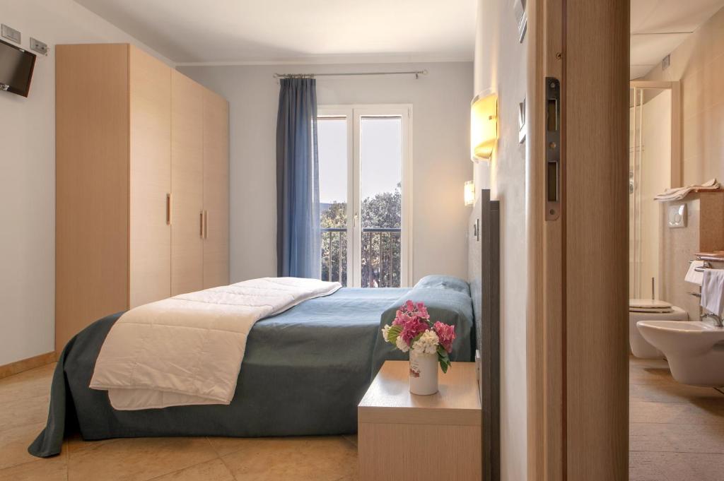 une chambre avec un lit et une salle de bain avec une fenêtre dans l'établissement Residence Villa Lo Scoglietto, à San Vincenzo