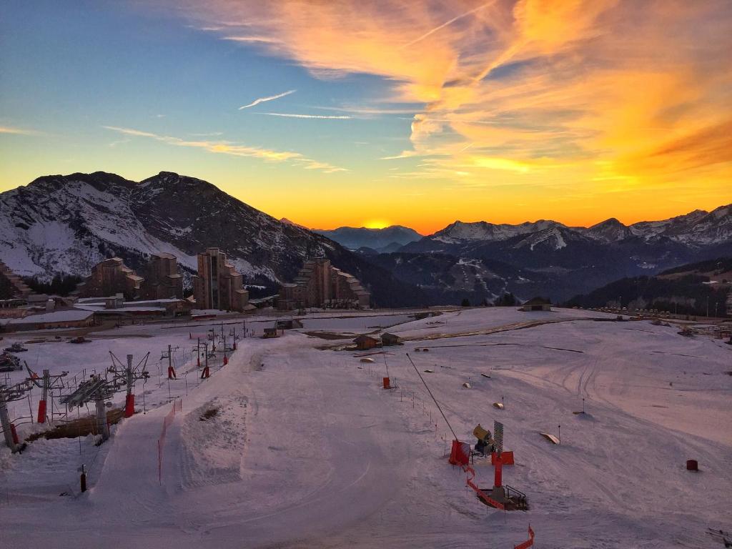 une piste de ski avec un coucher de soleil dans les montagnes dans l'établissement Appartement Studio Avoriaz, à Avoriaz 9 autres photos