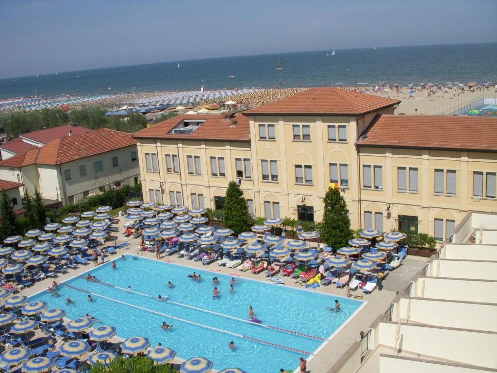 une vue aérienne d'une piscine avec parasols et une plage dans l'établissement Hotel Dante Family Spa Resort, à Cervia