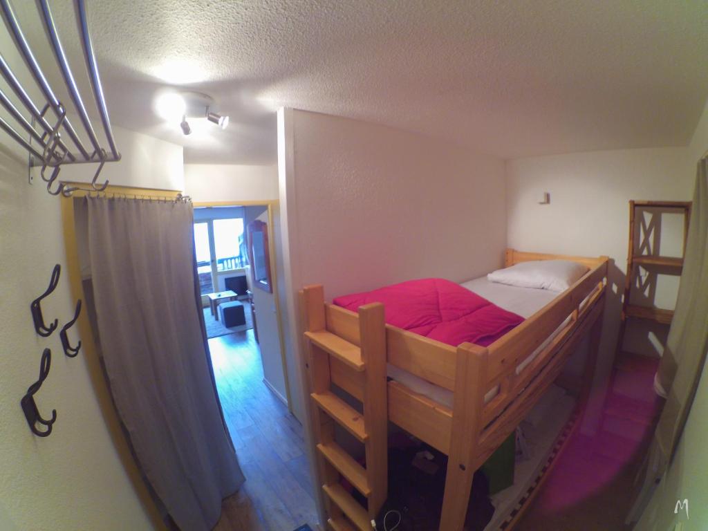 - une chambre avec des lits superposés et des draps rouges dans l'établissement Appartement Studio Avoriaz, à Avoriaz