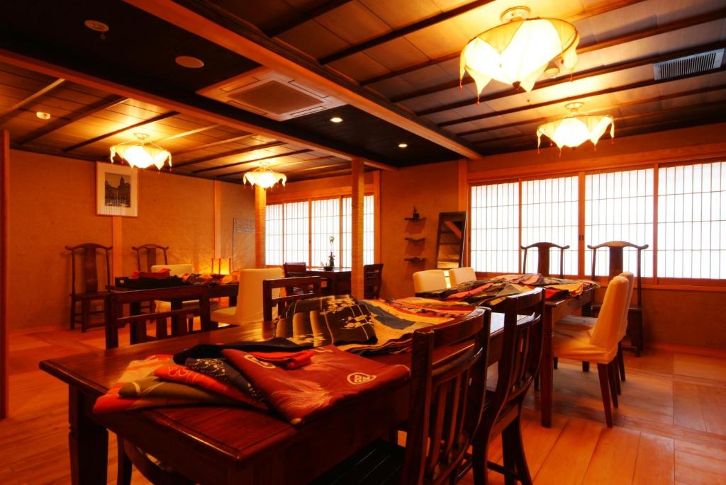 une salle à manger avec une longue table et des chaises dans l'établissement 城崎温泉 但馬屋-Tajimaya-, à Toyooka
