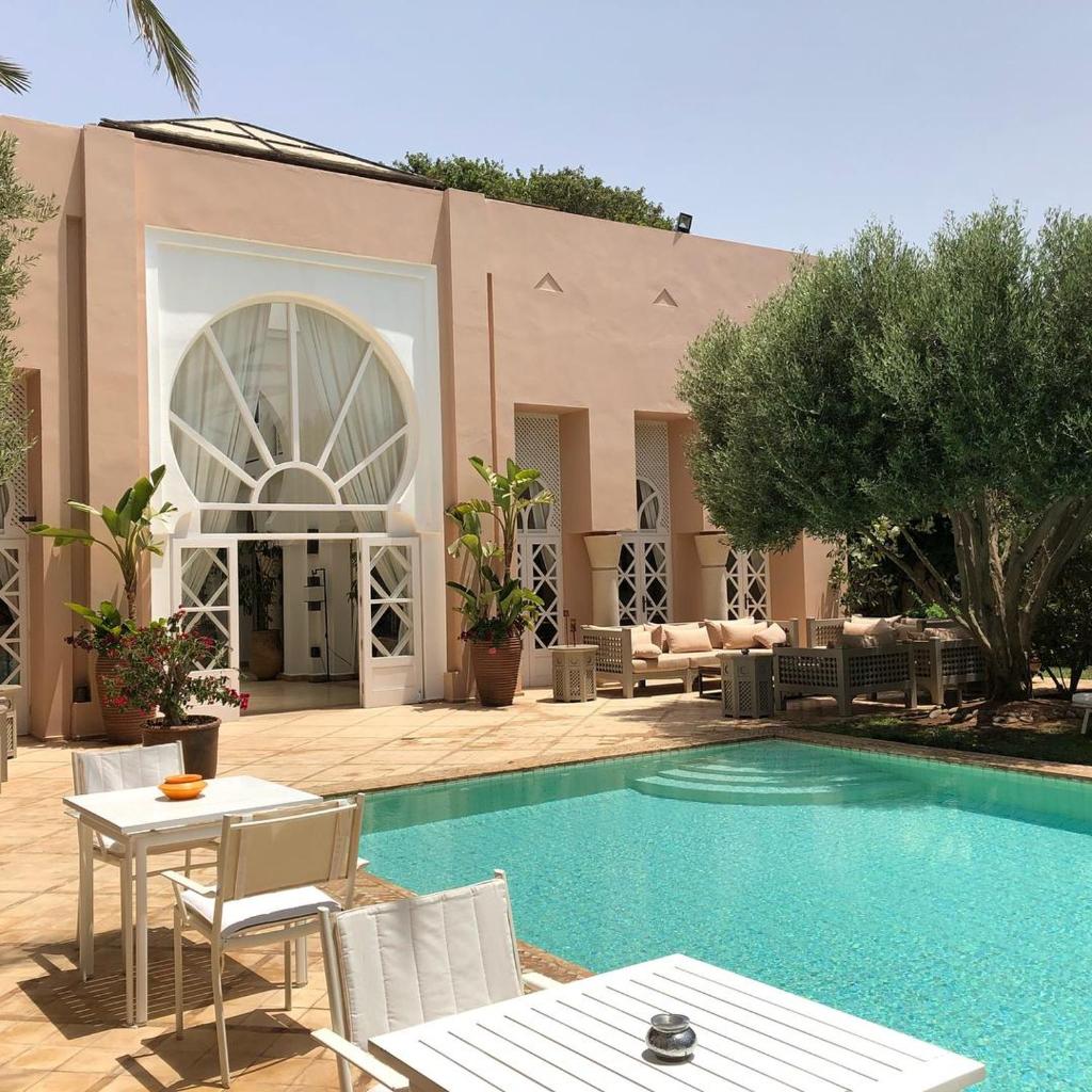 une piscine avec des chaises et une table et un bâtiment dans l'établissement Riad des Golfs, à Agadir