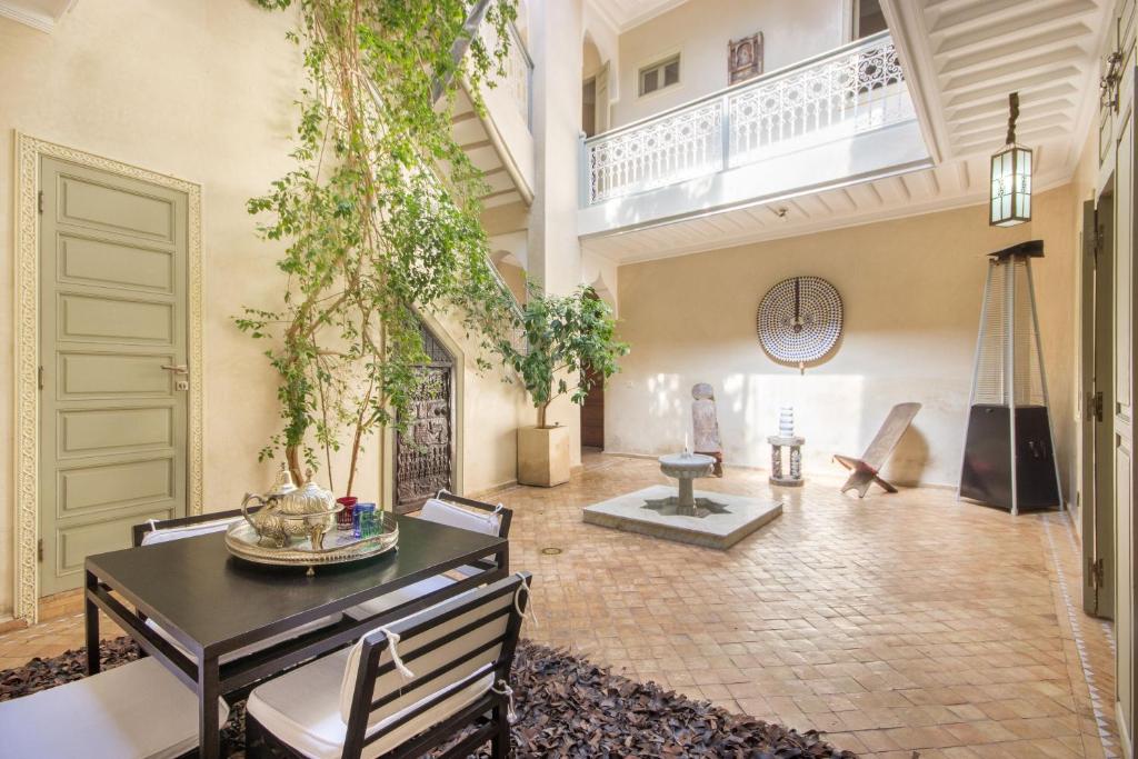 un grand salon avec une table et des chaises dans l'établissement Riad Privé De Luxe Au Coeur De La Kasbah Avec Hammam, à Marrakech
