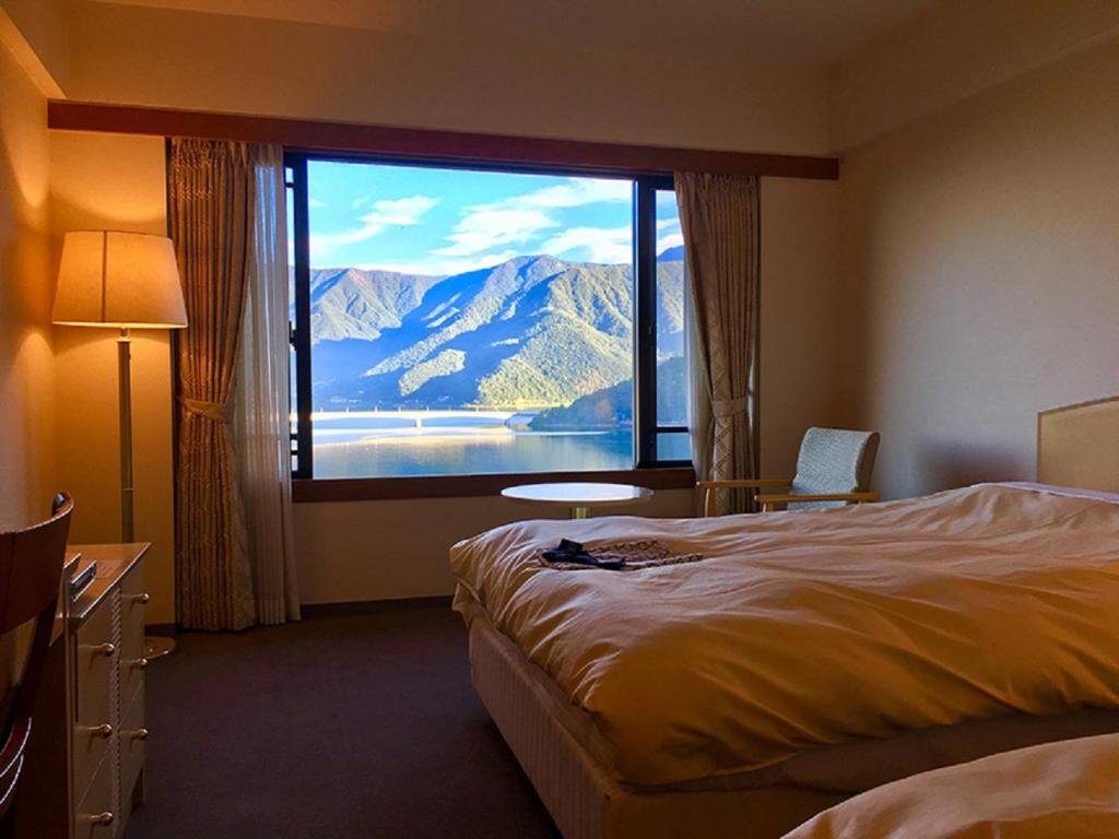 Cette chambre d'hôtel dispose d'une grande fenêtre offrant une vue sur la montagne. dans l'établissement Breezbay Lake Resort Kawaguchiko, à Fujikawaguchiko