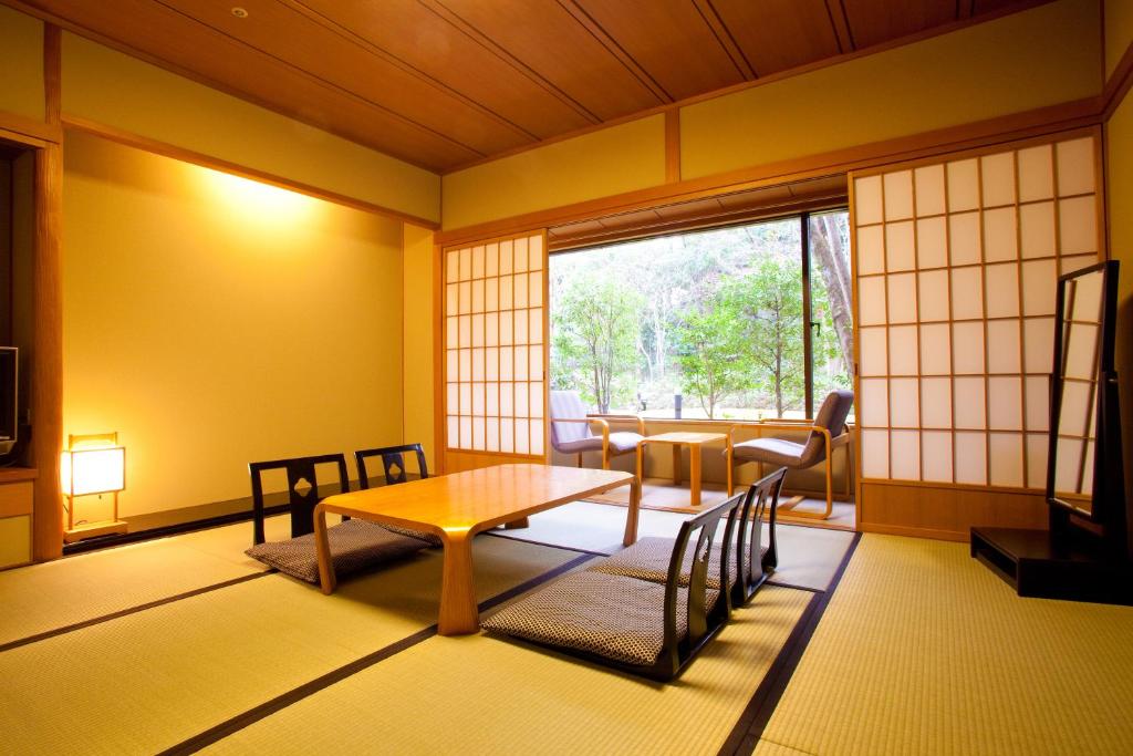 une pièce avec une table, des chaises et une fenêtre dans l'établissement Ranzan, à Kyoto