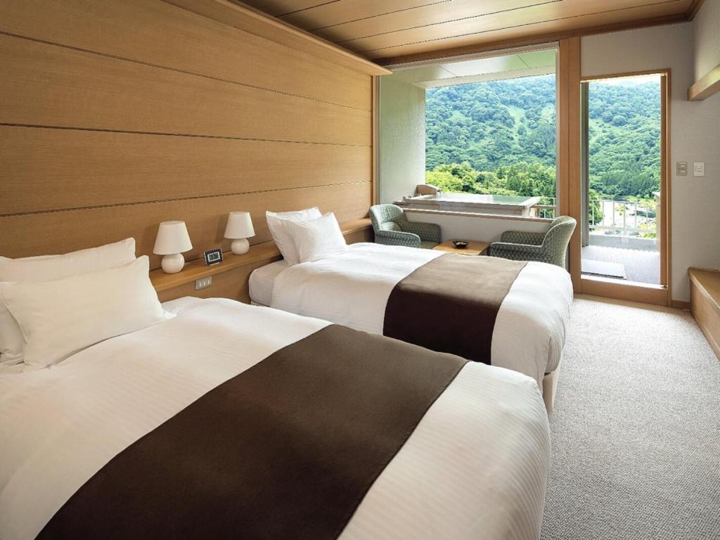 une chambre d'hôtel avec deux lits et une fenêtre dans l'établissement Marumine Kanko Hotel, à Aizuwakamatsu