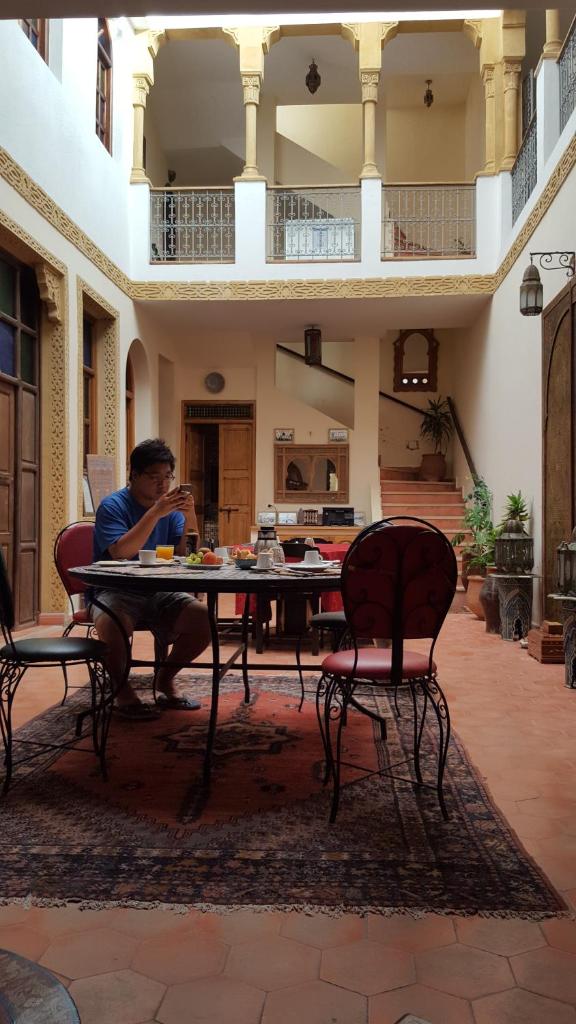un homme assis à une table dans une pièce dans l'établissement dar wassim el ghali, à Rabat