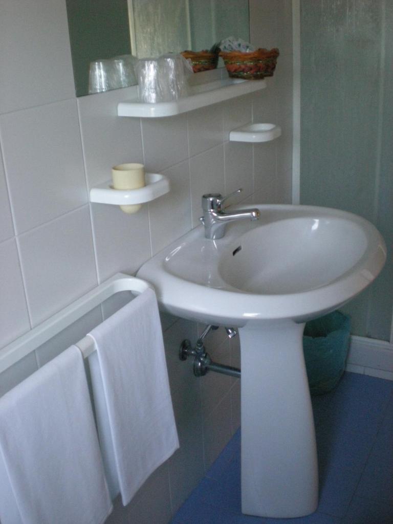 La salle de bains est pourvue d'un lavabo blanc et de serviettes. dans l'établissement Residence Ducale, à Rodi Garganico 36 autres photos