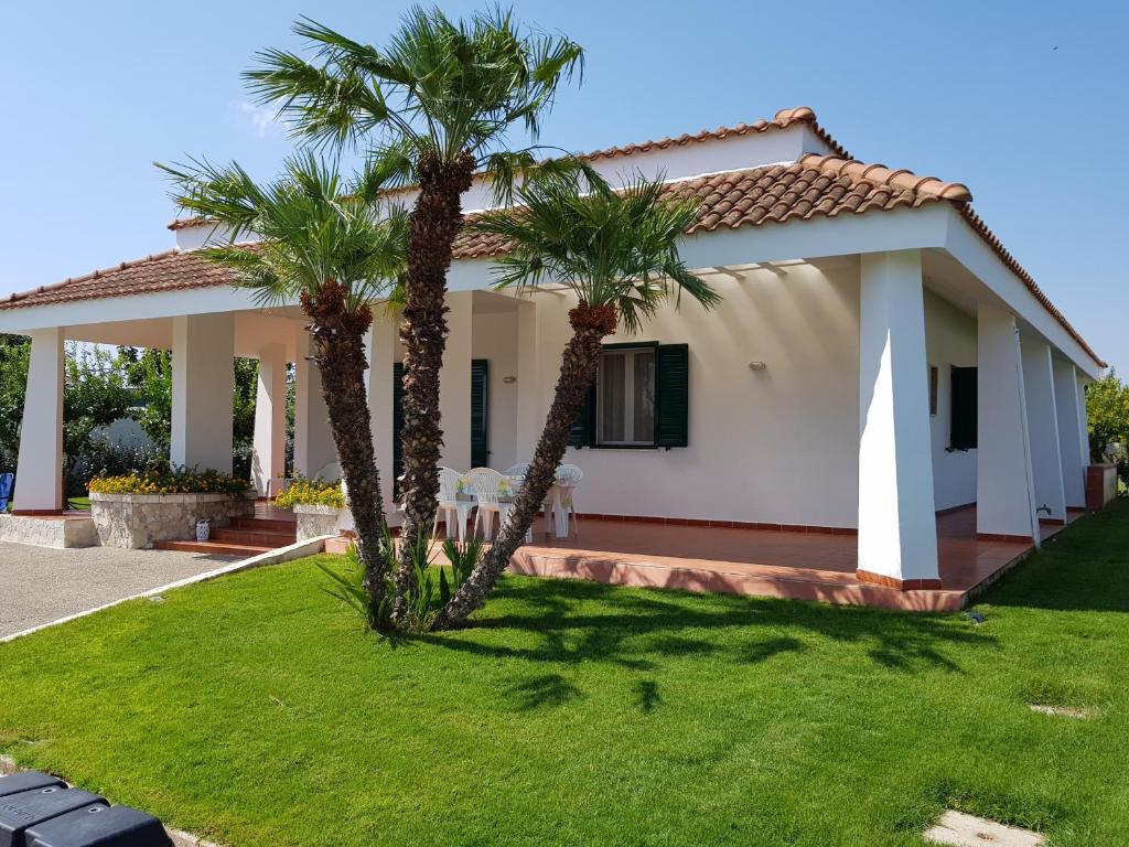 une maison avec deux palmiers devant elle dans l'établissement Villa Brancasi con piscina, à Brindisi