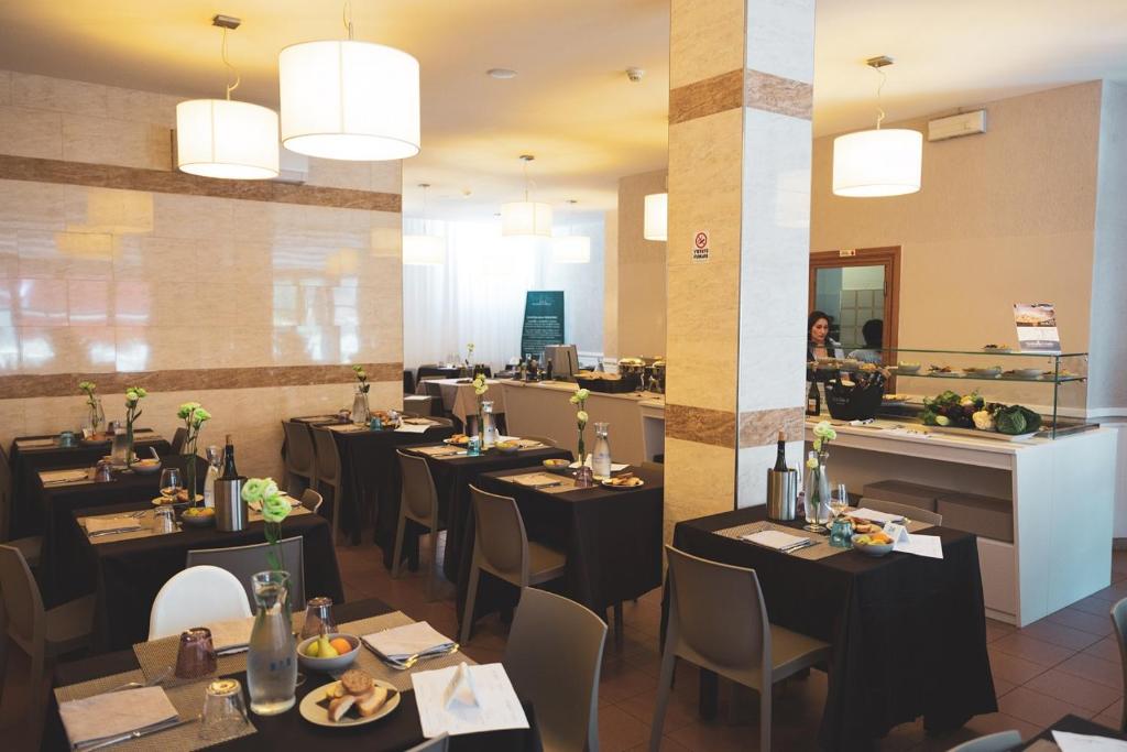 un restaurant avec des tables et des chaises noires et un comptoir dans l'établissement Hotel Venezia New, à Vasto