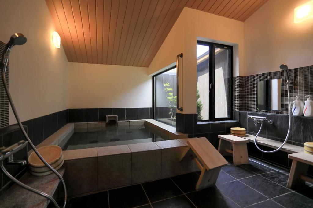 une grande salle de bain avec baignoire et douche dans l'établissement Jinpuso, à Miyazu