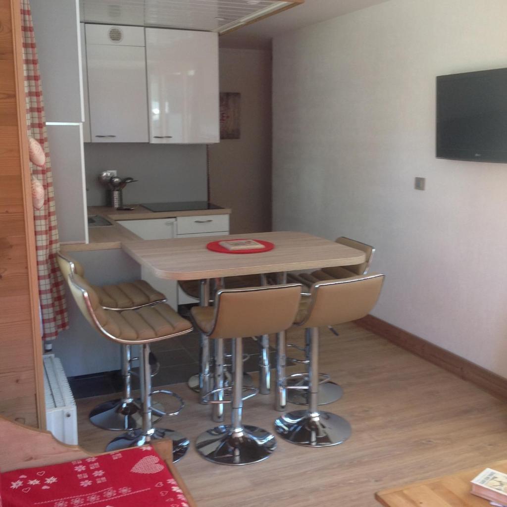 une cuisine avec une table et des chaises dans une pièce dans l'établissement Prariond 5, à Tignes 15 autres photos