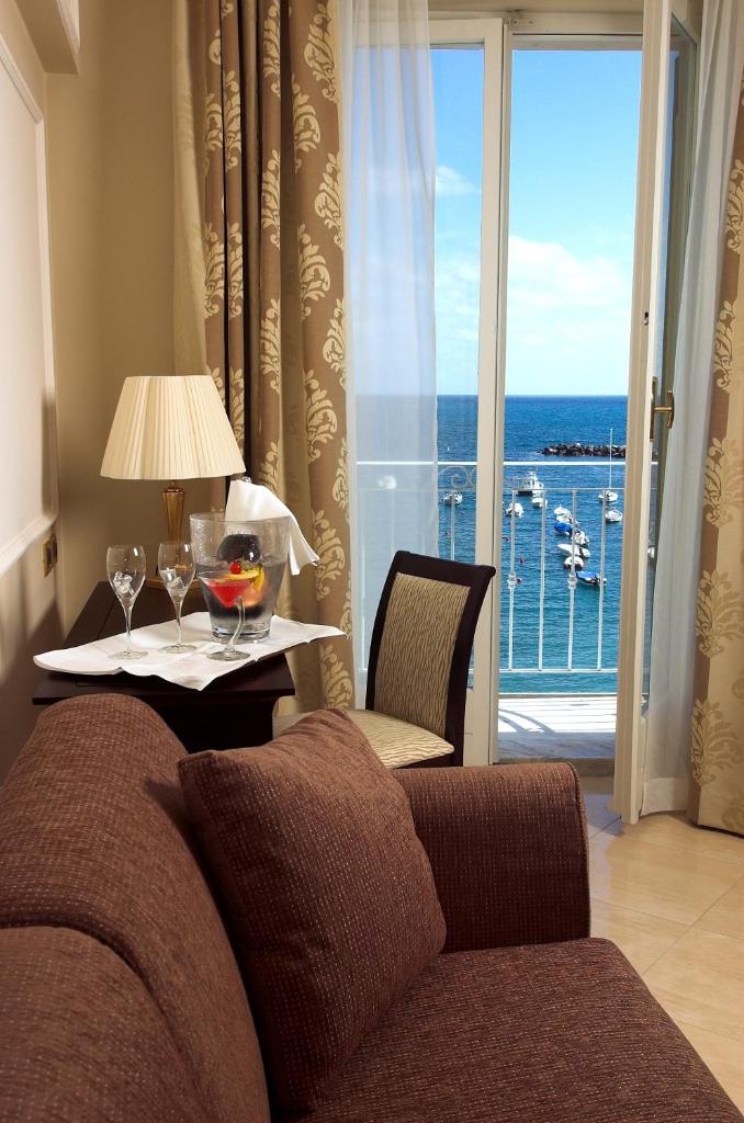 - un salon avec un canapé et une table avec des verres à vin dans l'établissement Hotel Miramare & Spa, à Sestri Levante 188 autres photos