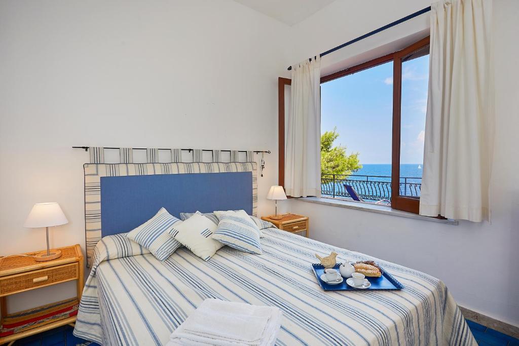 une chambre avec un lit avec vue sur l'océan dans l'établissement Villa Majus, à Porticello