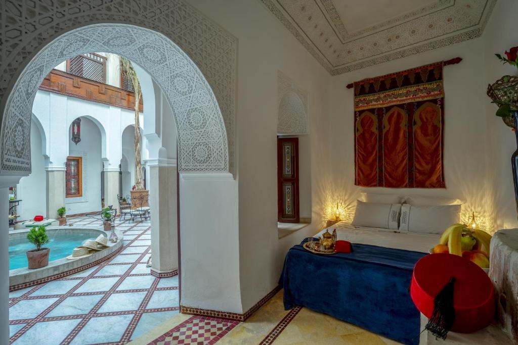 - une chambre avec un lit et une piscine dans l'établissement Riad Safran et Cannelle & Spa, à Marrakech