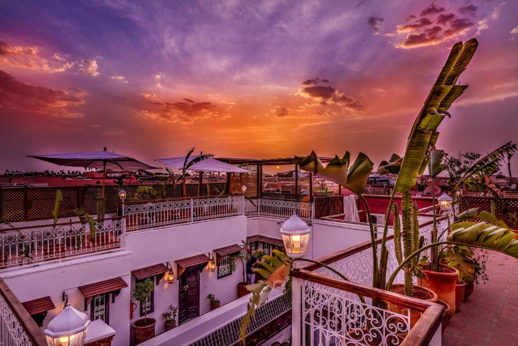 - une vue sur un bâtiment avec un coucher de soleil en arrière-plan dans l'établissement Riad Safran et Cannelle & Spa, à Marrakech