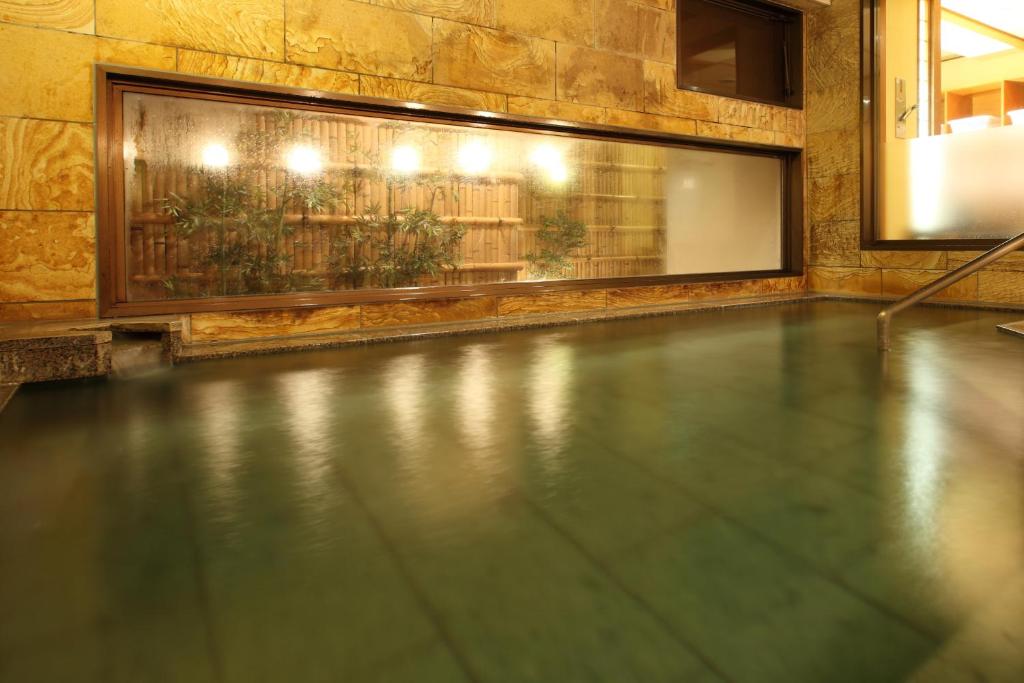 - une piscine avec du carrelage et une fenêtre dans l'établissement Tsuruya Ryokan, à Karuizawa