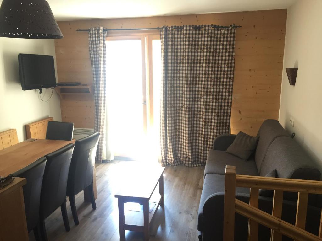 un salon avec un canapé et une table dans l'établissement Duplex Familial à Vars, Chalets des Rennes, à Vars