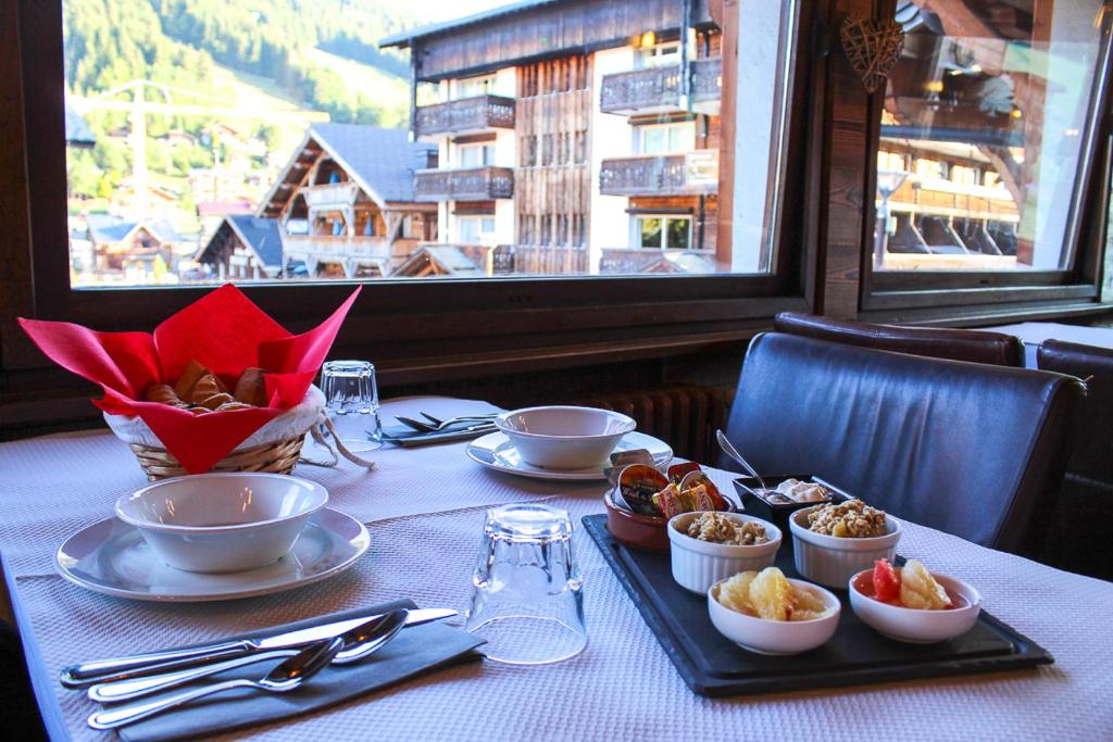 une table avec des assiettes de nourriture sur une table dans un restaurant dans l'établissement Hotel Le Christiania, aux Gets