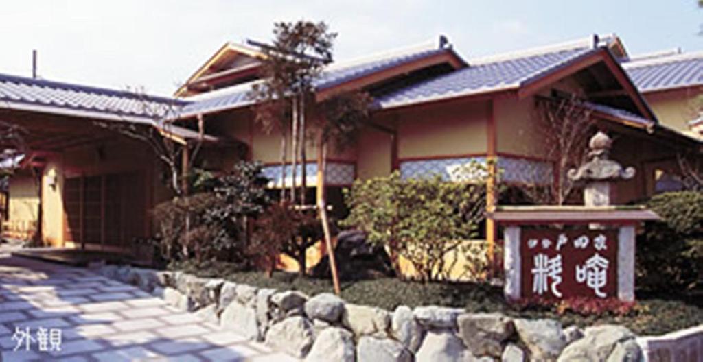 une maison avec une clôture en pierre devant elle dans l'établissement Ise Todaya Ryoan, à Ise