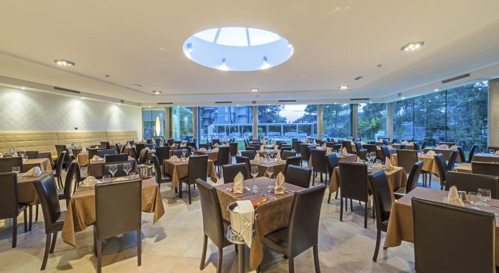 une grande salle de banquet avec tables et chaises dans l'établissement Hotel San Marco, à Bibione