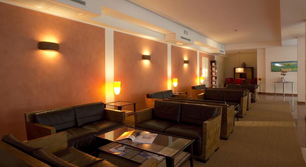 - un salon avec des canapés en cuir et une table dans l'établissement Hotel San Marco, à Bibione