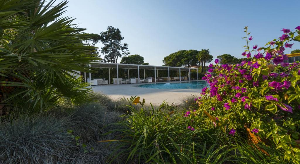 un complexe avec une piscine et quelques fleurs dans l'établissement Hotel San Marco, à Bibione