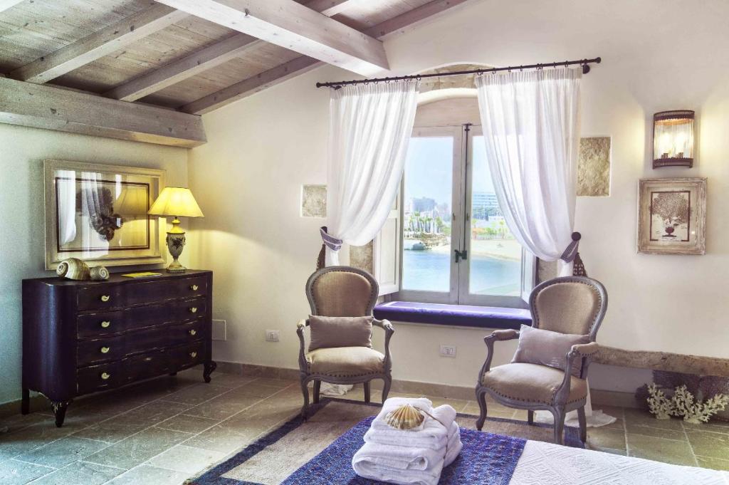 - une chambre avec deux chaises et une fenêtre dans l'établissement Musciara Siracusa Resort, à Syracuse
