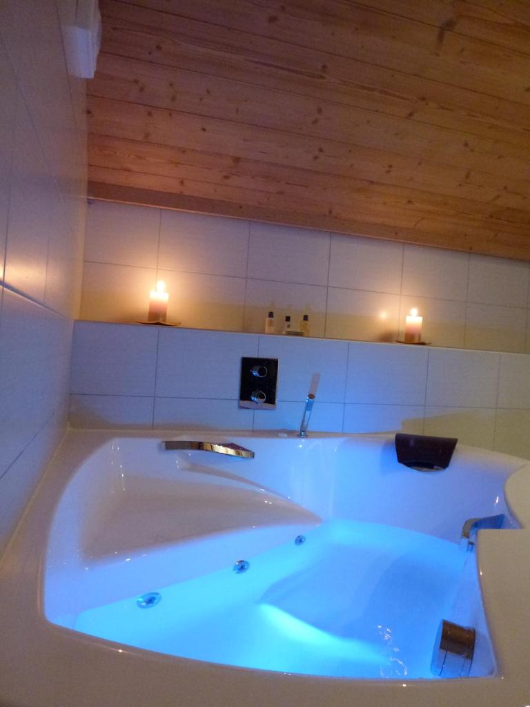 Cette chambre dispose d'une grande baignoire et de plafonds en bois. dans l'établissement Hôtel Restaurant "Les Sapins" Wellness & Gourmet, à Manigod