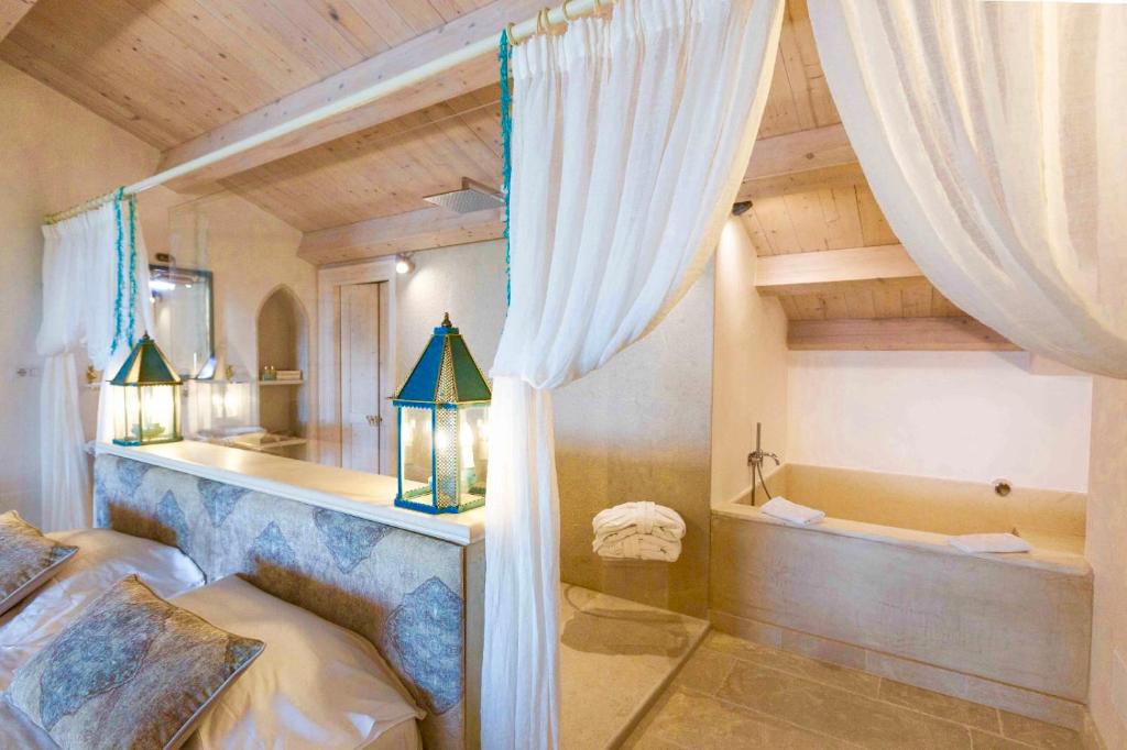 une chambre avec un lit et une baignoire dans une pièce dans l'établissement Musciara Siracusa Resort, à Syracuse