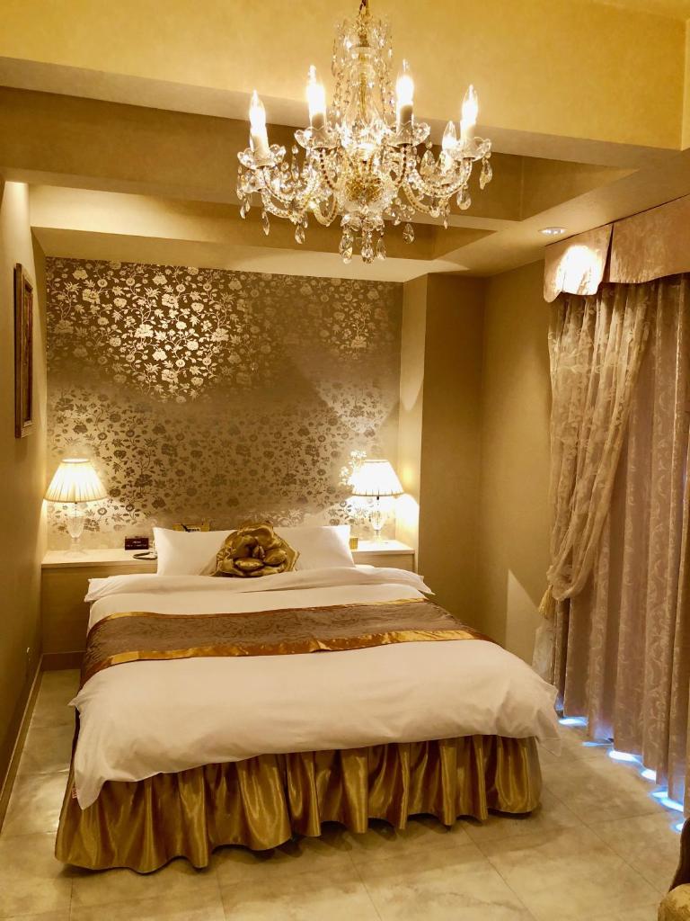 une chambre avec un grand lit et un lustre dans l'établissement Hotel Star Dust (Adult Only), à Hiroshima