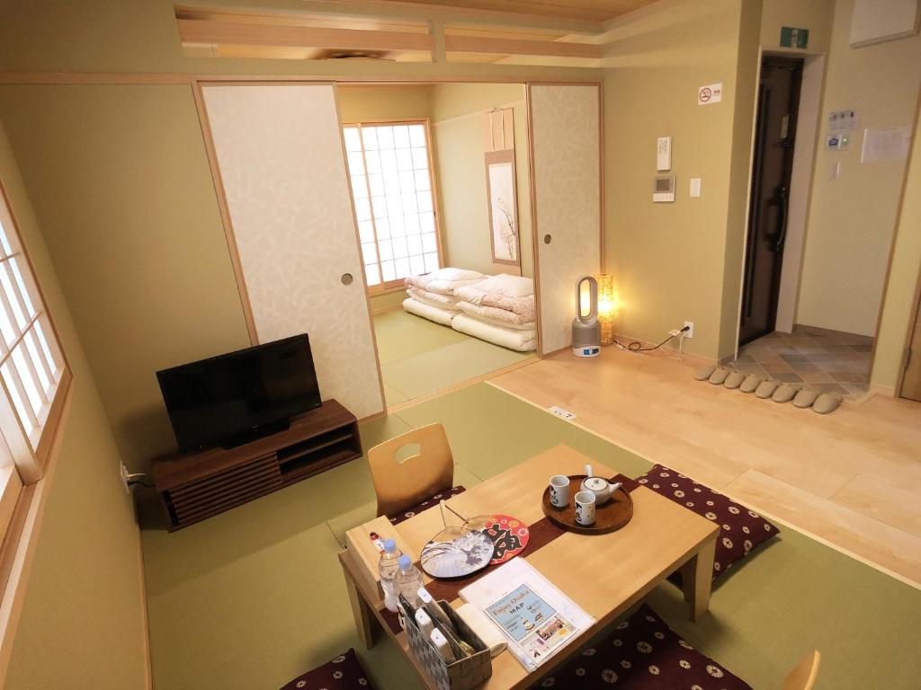- un salon avec une table et une télévision dans l'établissement Harper House, à Osaka
