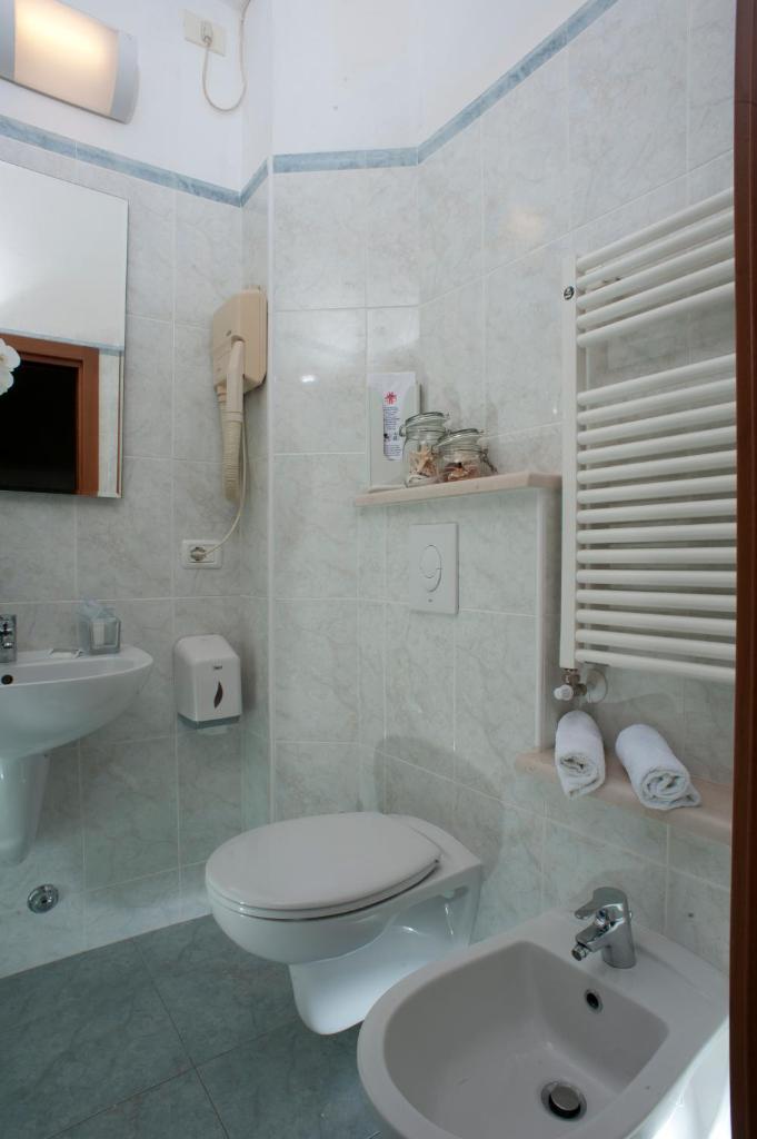 une salle de bain blanche avec toilettes et lavabo dans l'établissement Hotel Alsen, à Rimini