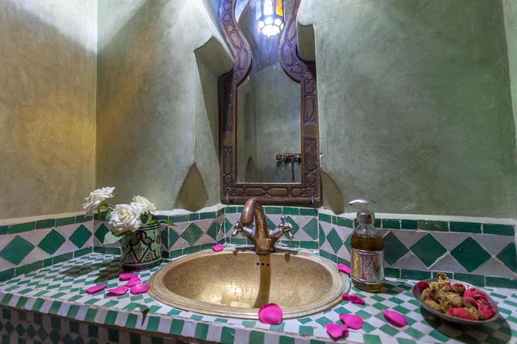 une salle de bain avec un lavabo et un miroir dans l'établissement Riad Tasneem, à Marrakech