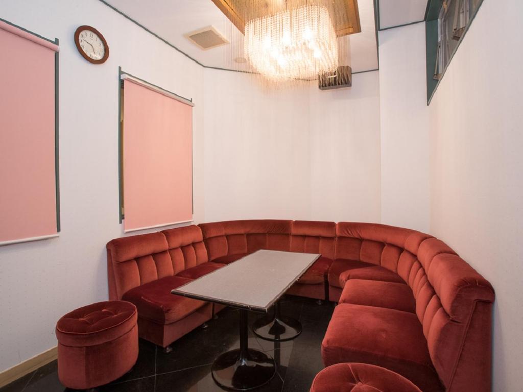 une salle de réunion avec un canapé rouge et une table dans l'établissement Itoen Hotel Iizakakanouya, à Fukushima 37 autres photos