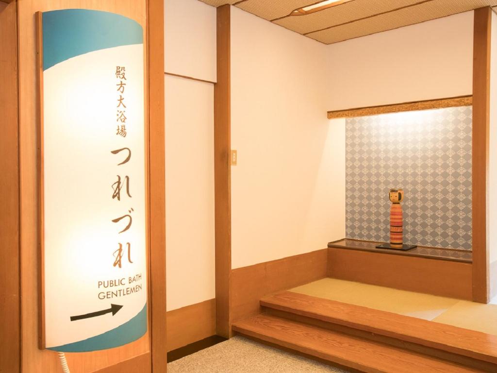 Cette chambre dispose d'une porte avec un panneau indiquant le temple d'une grande entrée. dans l'établissement Itoen Hotel Iizakakanouya, à Fukushima