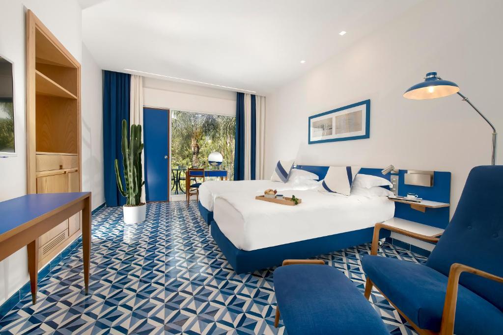 une chambre d'hôtel avec un lit et des chaises dans l'établissement Parco dei Principi, à Sorrente