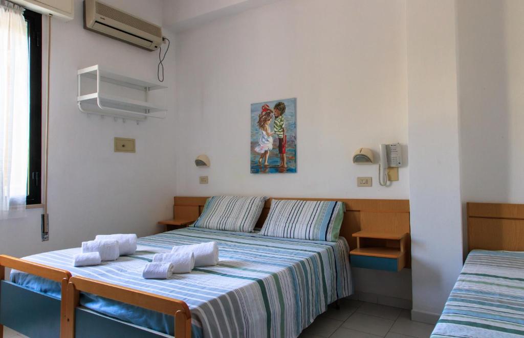 une chambre avec deux lits avec des serviettes dessus dans l'établissement Hotel Riziana, à Cervia