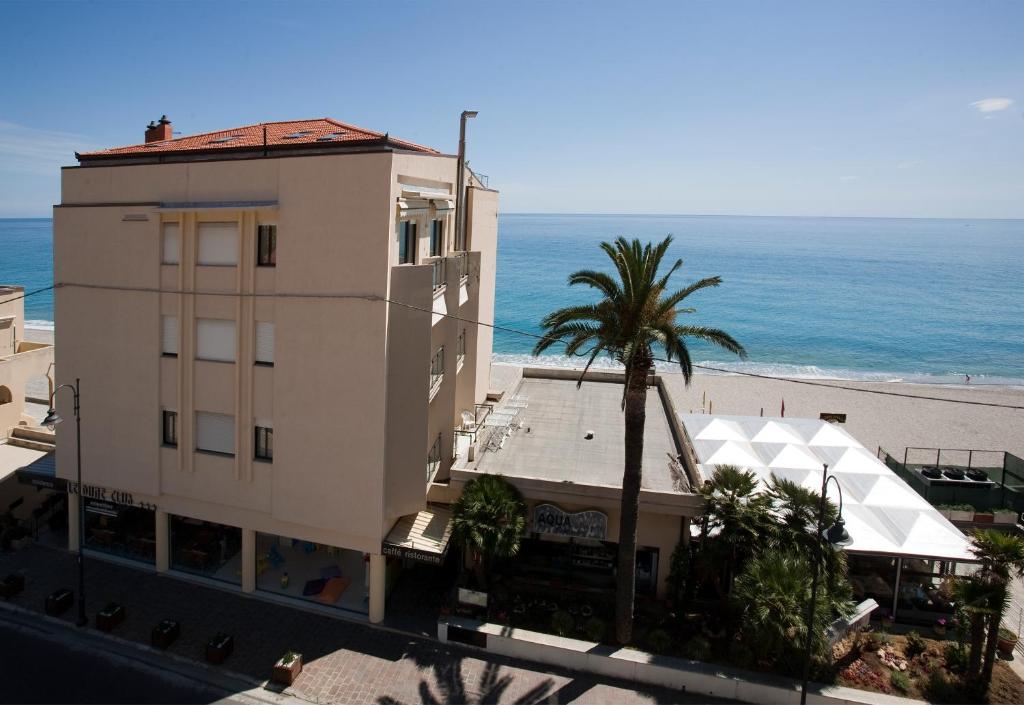 un bâtiment avec un palmier à côté d'une plage dans l'établissement Residence Le Dune Club, à Varigotti