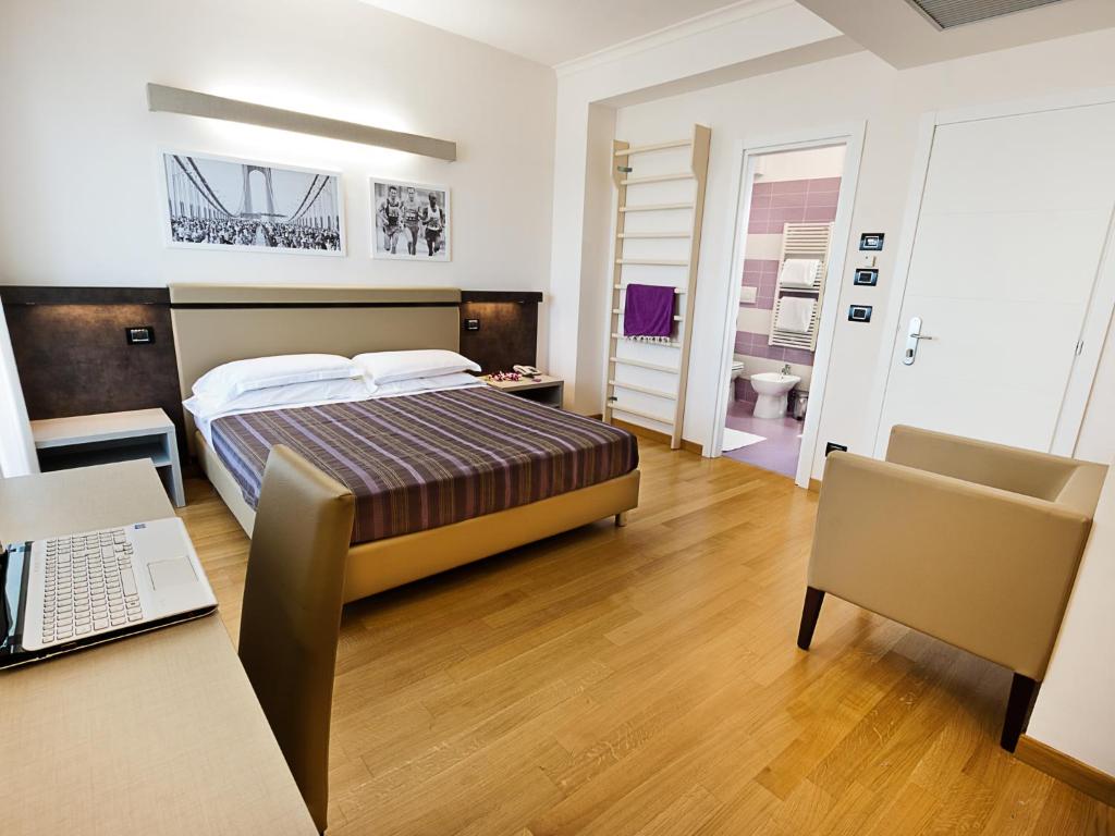 - une chambre avec un lit, un bureau et un ordinateur portable dans l'établissement Hotel Sporting, à San Benedetto del Tronto