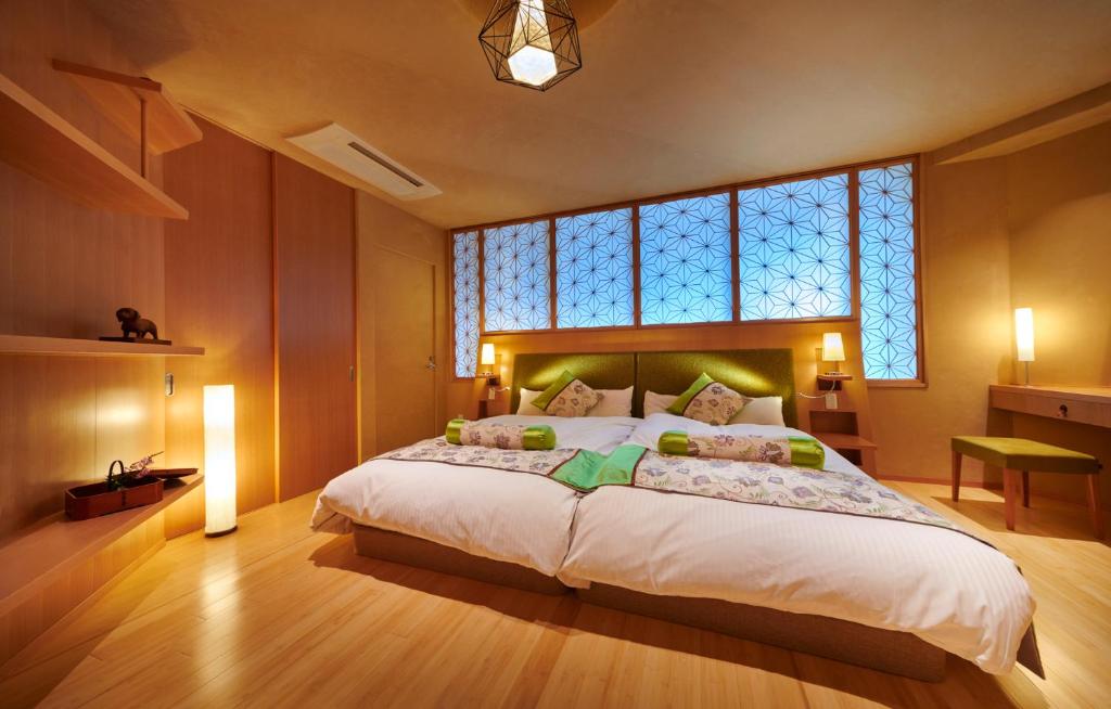 une chambre avec un grand lit avec une grande fenêtre dans l'établissement Honjin Hiranoya Kachoan, à Takayama