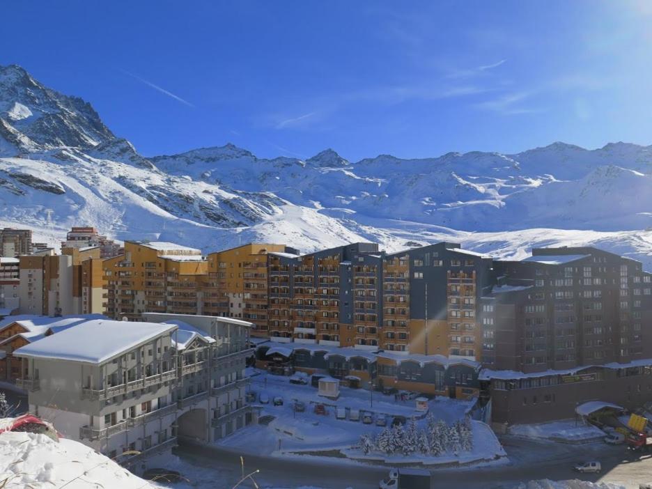 un bâtiment avec des montagnes enneigées en arrière-plan dans l'établissement 2 pièce cabine Val Thorens, à Val Thorens