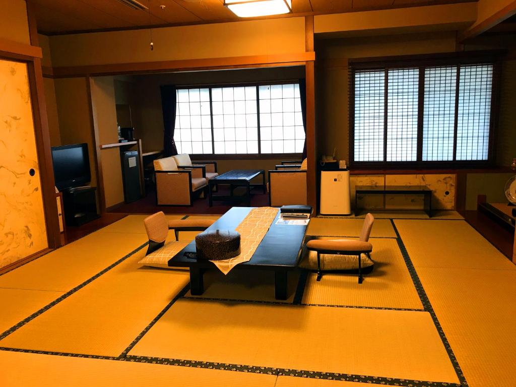 un grand salon avec une table et des chaises dans l'établissement Beppu Kannawa Onsen Oniyama Hotel, à Beppu